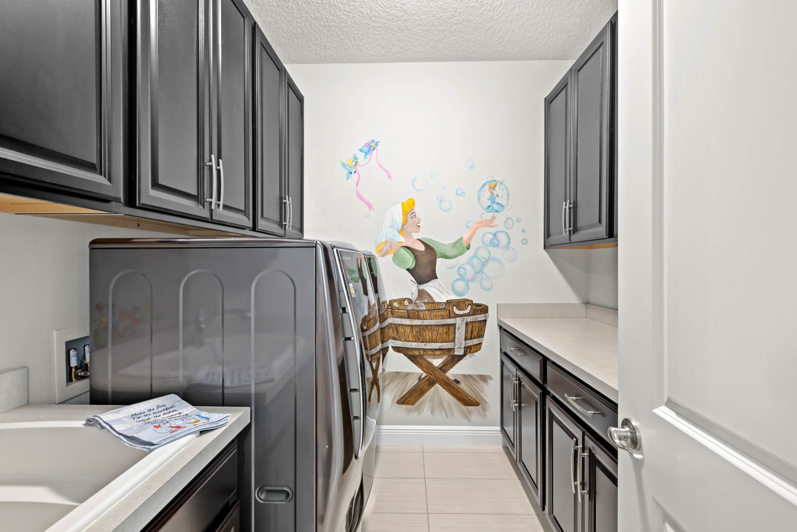laundry room with cabinets and cinderella painting
